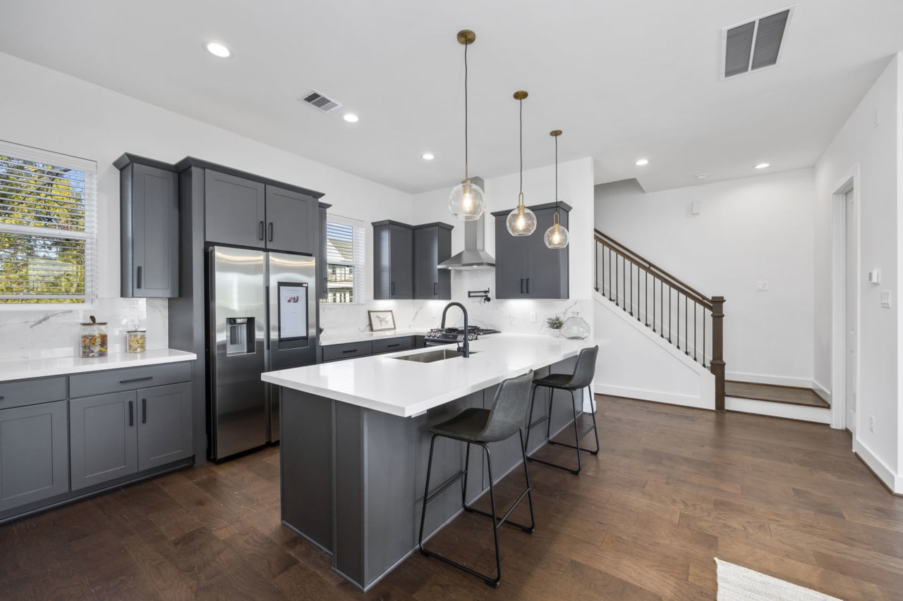 newly built kitchen with gray cabinets and stone counters