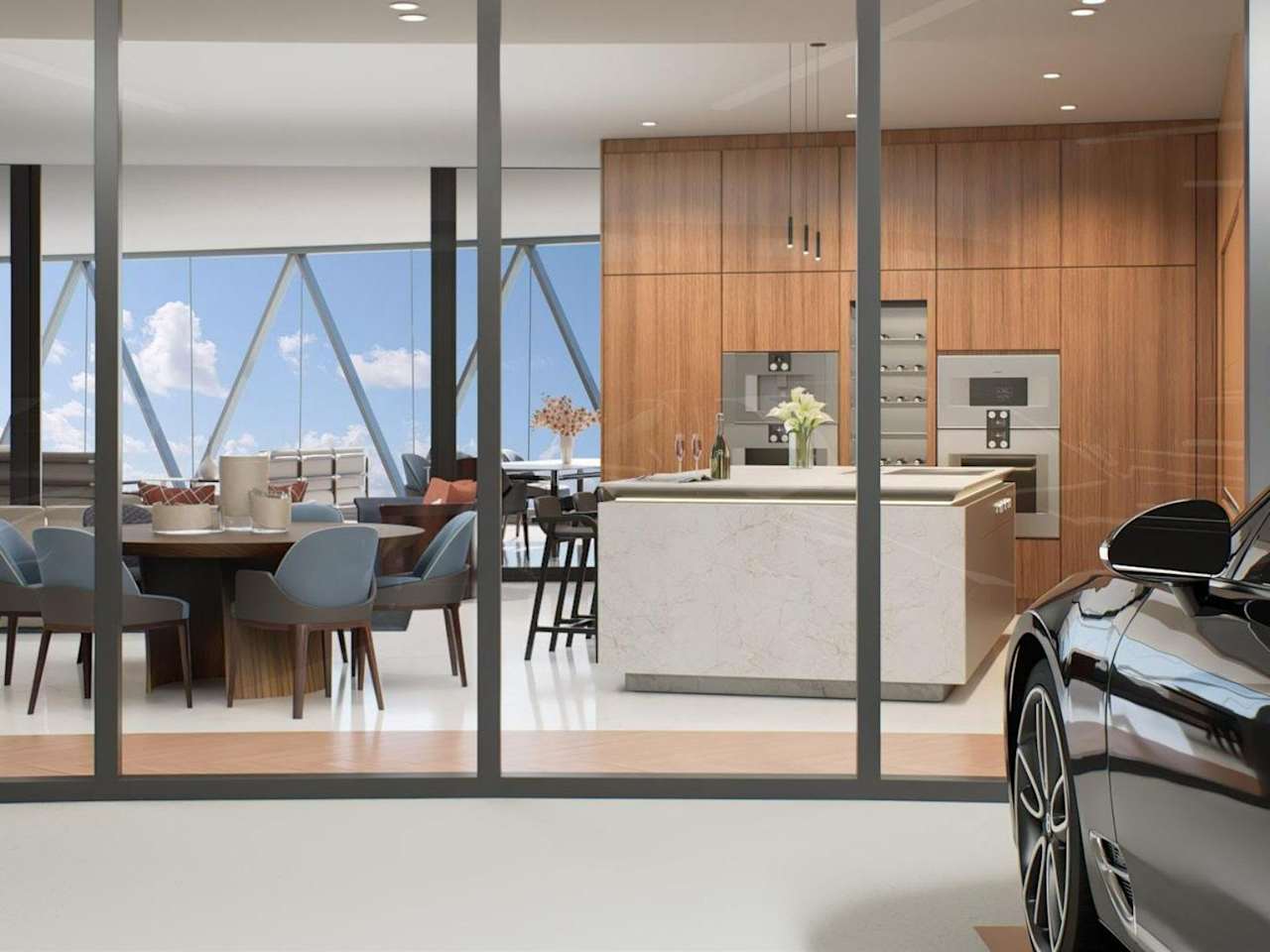 Luxury condo kitchen with a marble island, wood cabinetry, dining area, and car in the foreground.