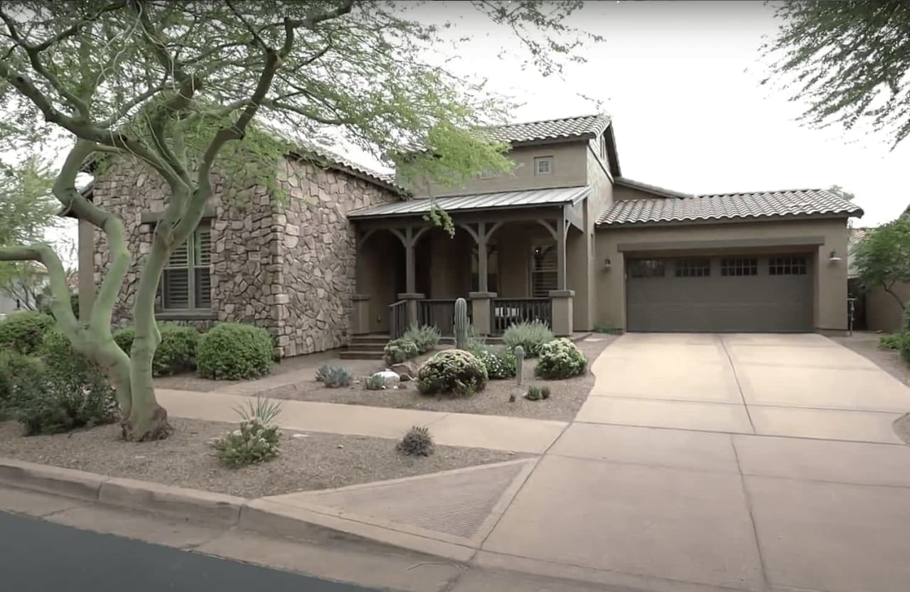 A charming suburban home with a spacious driveway and a garage.