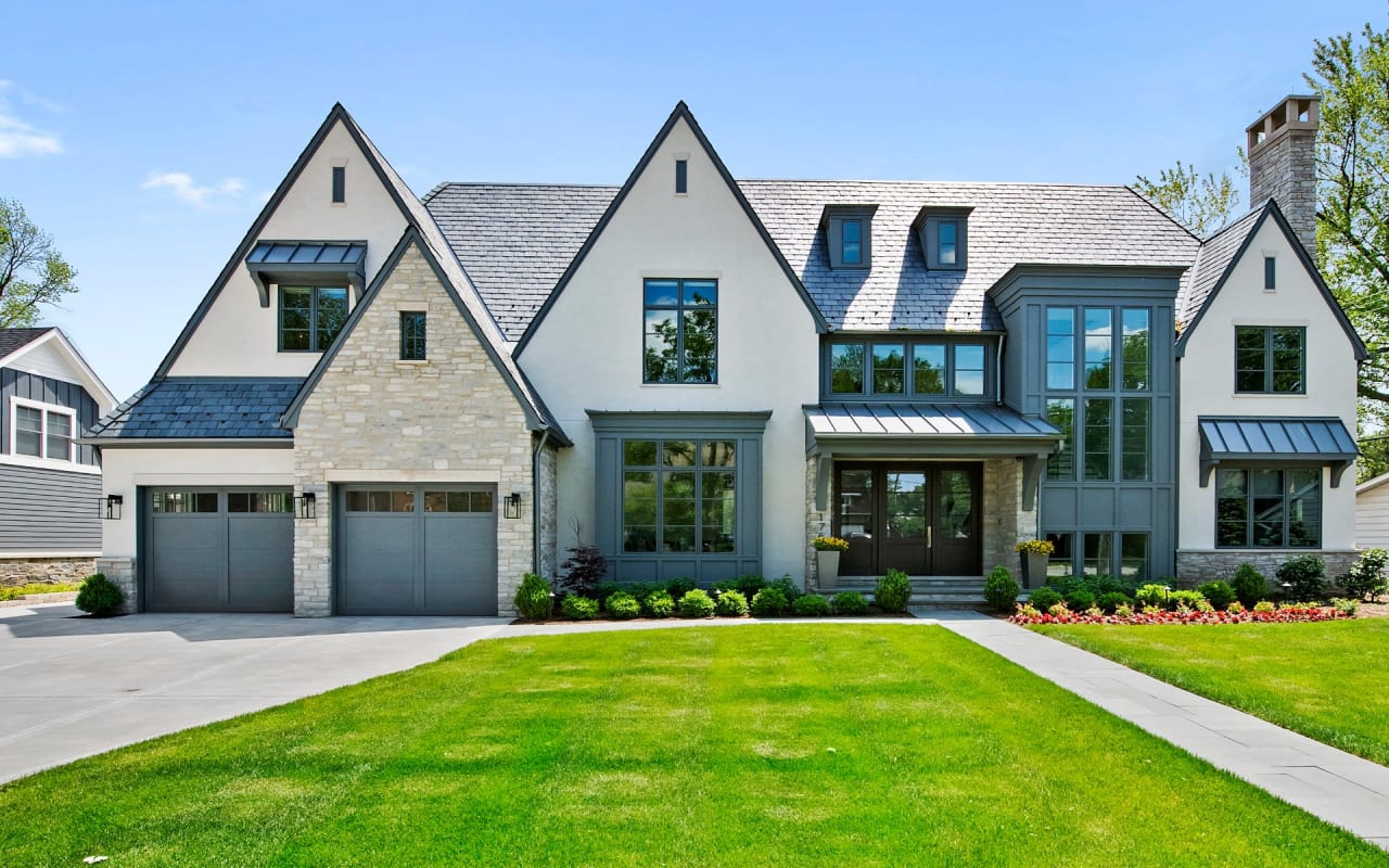 A large, two-story house with a brick exterior and a gray slate roof. 