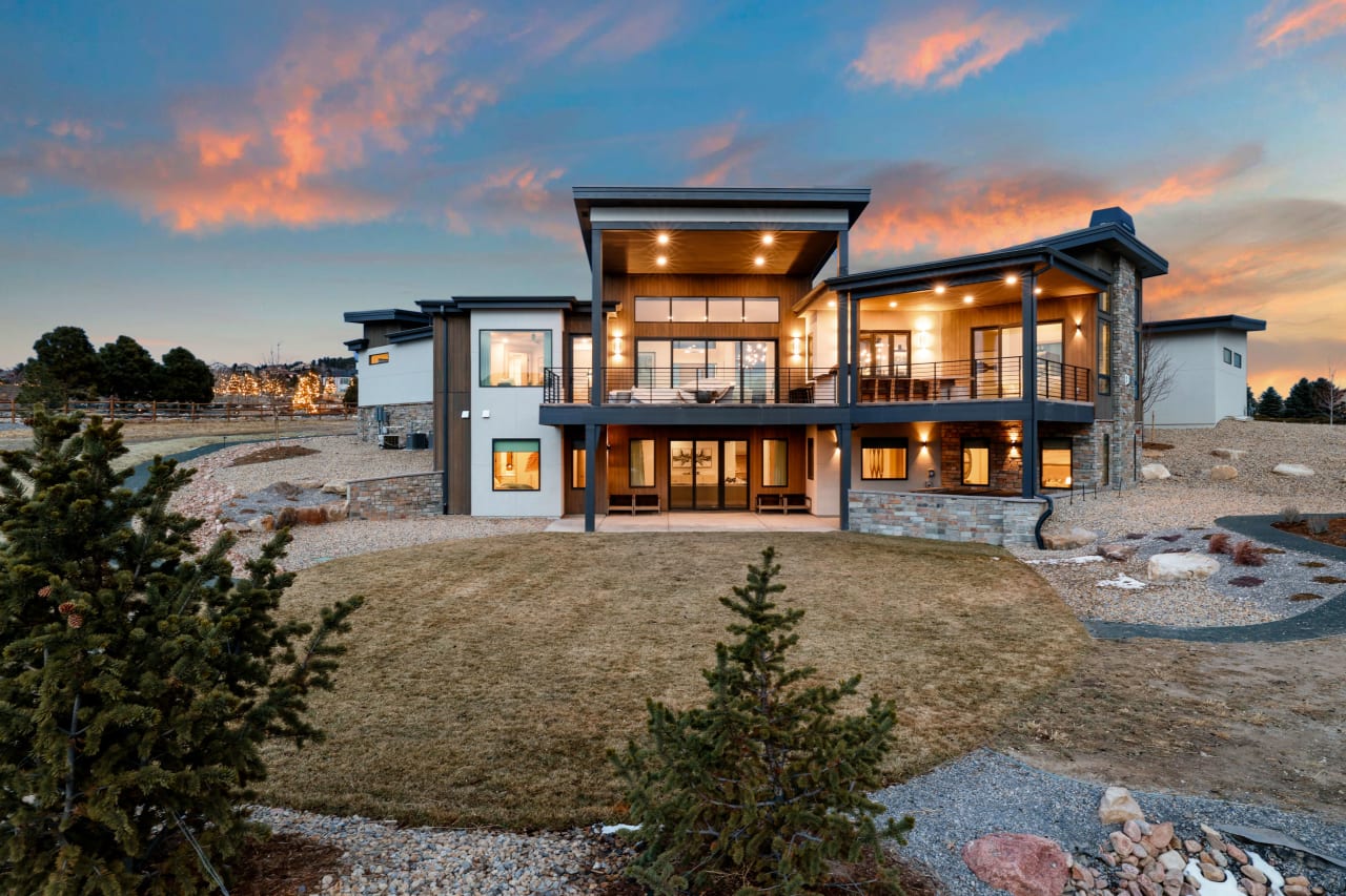 A photo of a large house with a lot of windows, located in a suburban neighborhood.