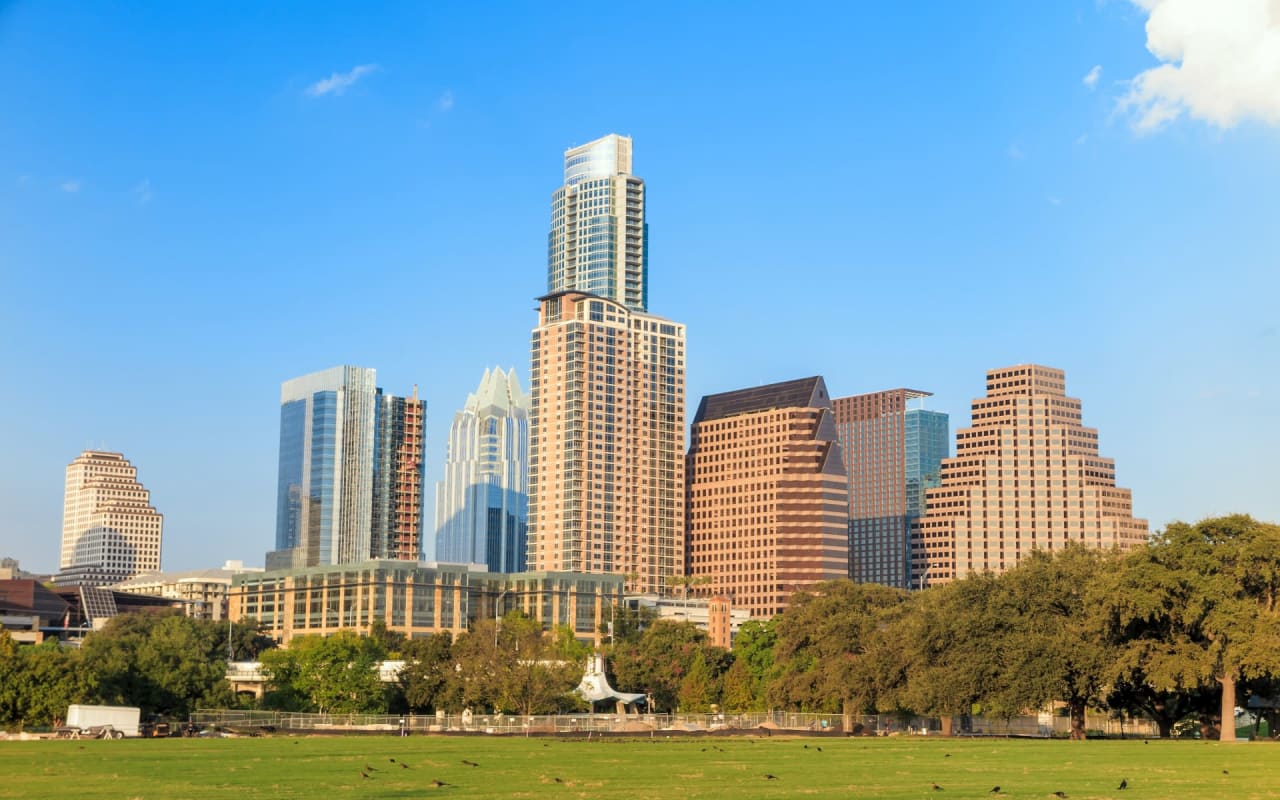 Tall Buildings with a Green Field in Front