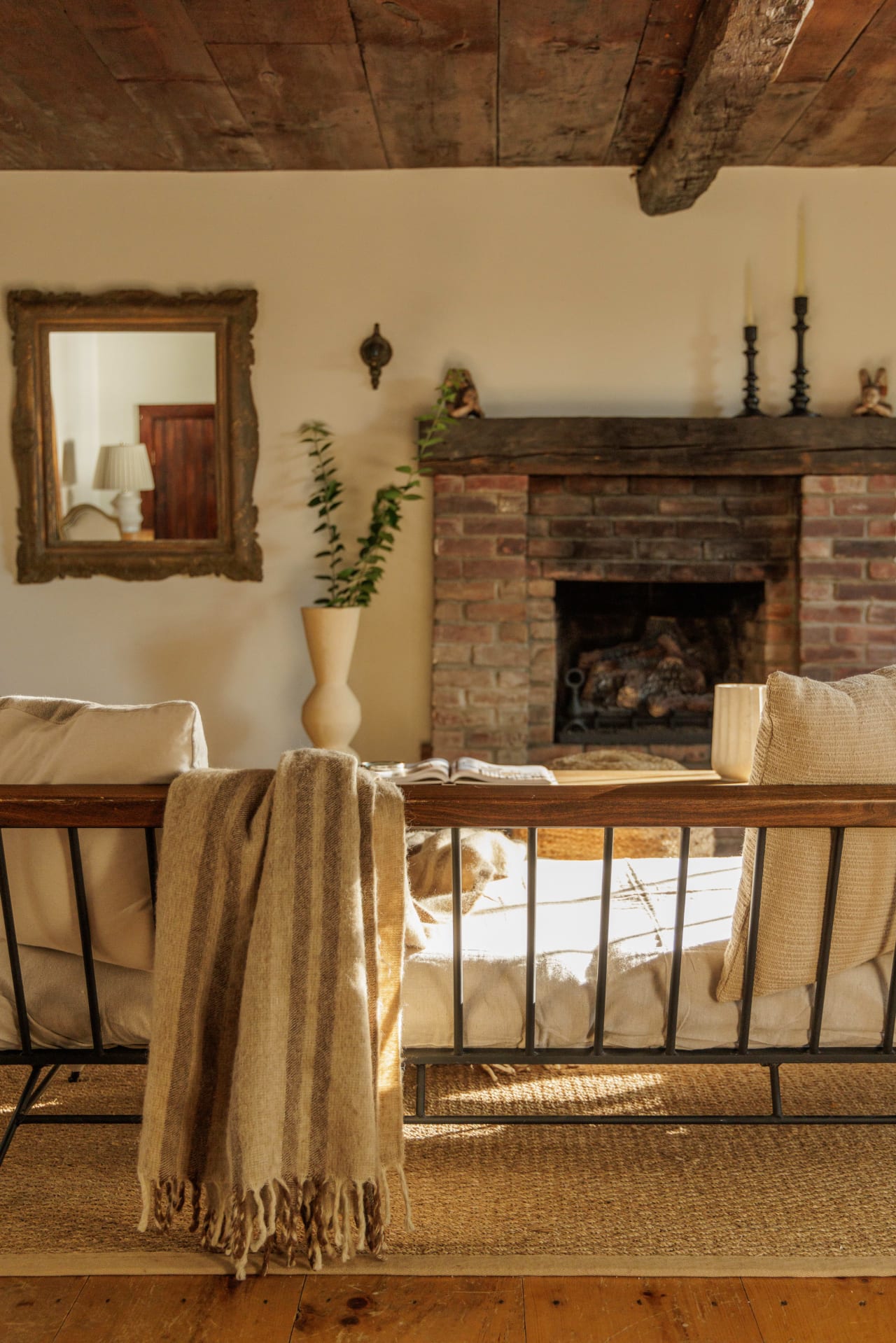 Living room furniture in front of the furnace with decoration and a mirror hanging on the wall