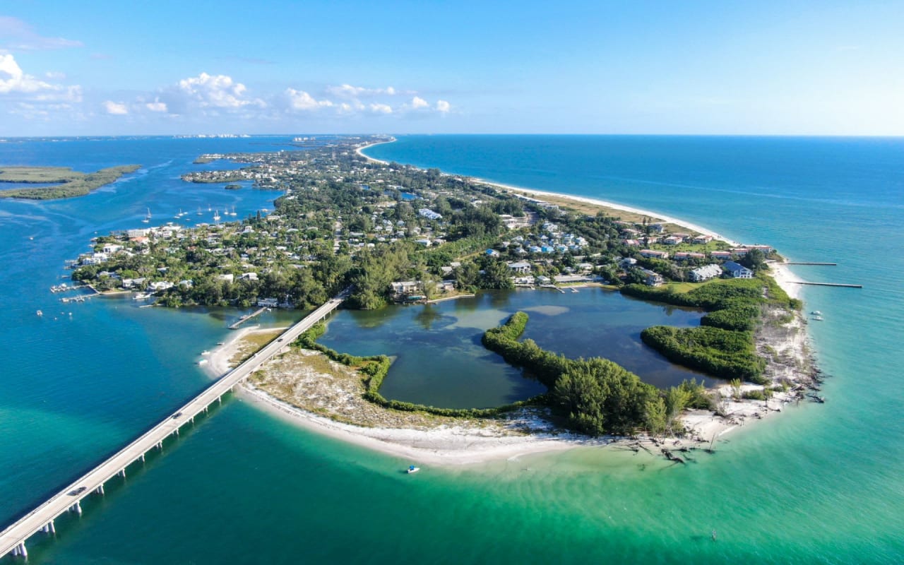 An aerial view of a small island with a neighborhood in the middle of the ocean.