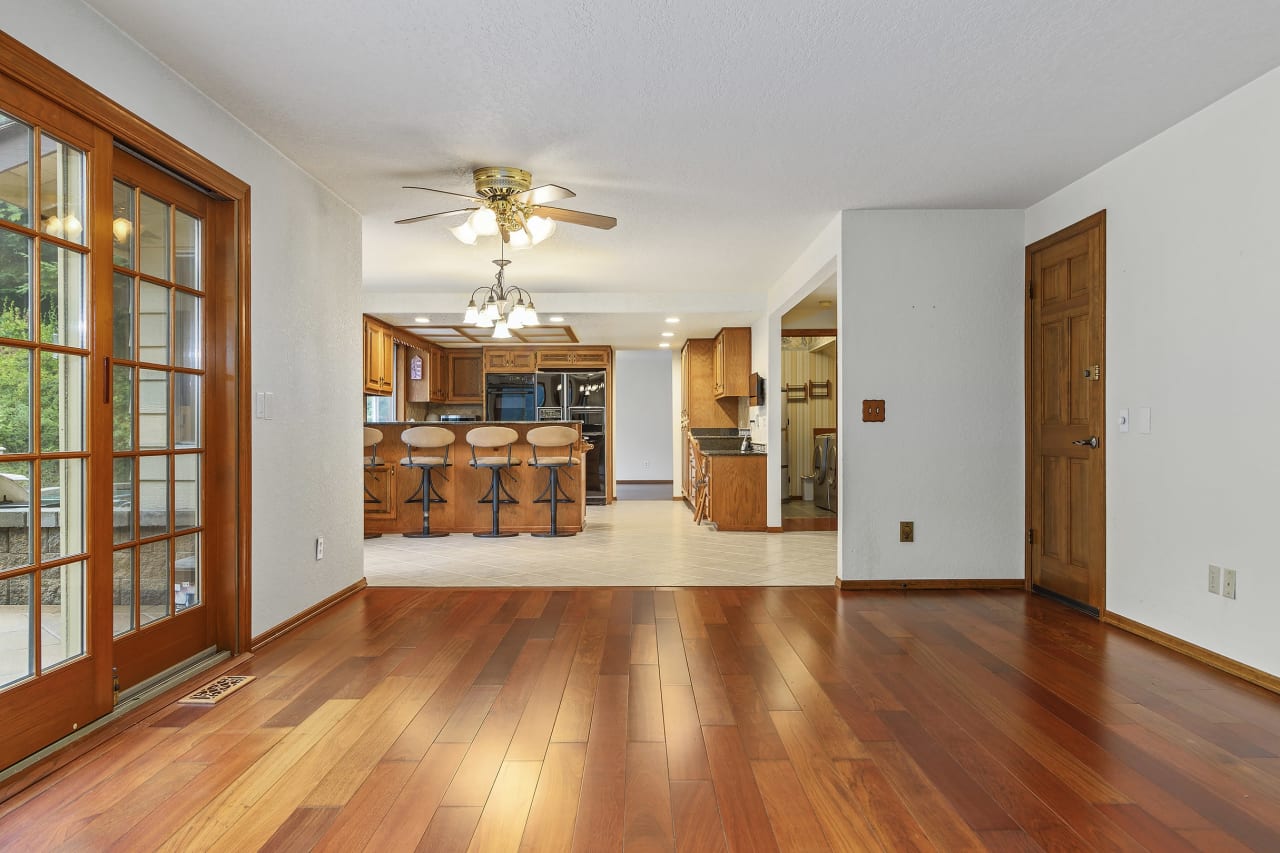 From the cozy family room, take in the inviting view of the dining area and kitchen bar. French doors lead to the backyard and patio, offering an effortless indoor-outdoor living experience, perfect for entertaining and relaxation.