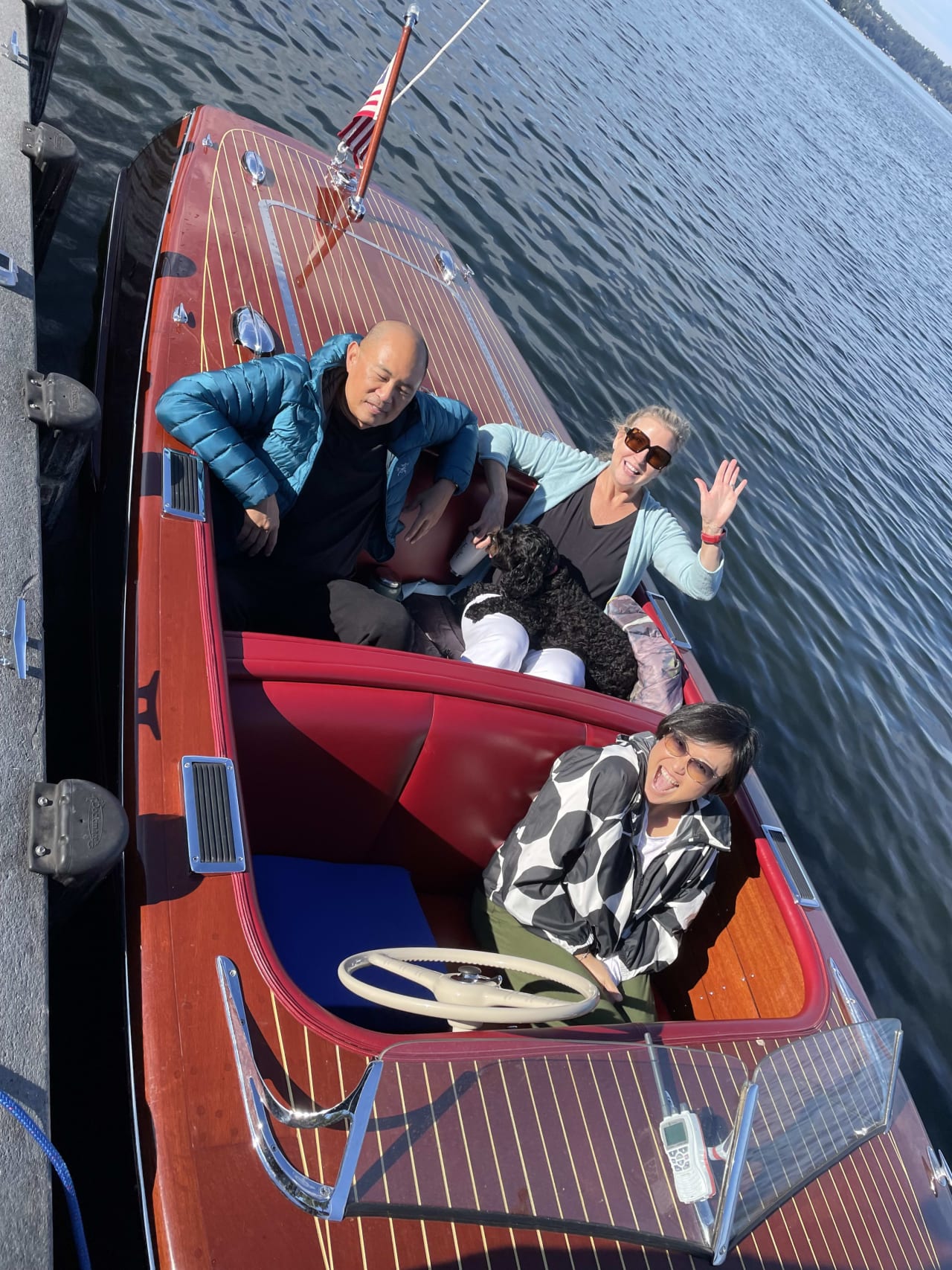 happy family riding on a red motorboat on a lake