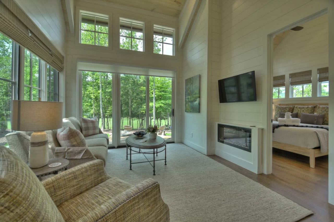 Living room with a fireplace and a couch next to it. There is a rug on the floor in front of the fireplace.