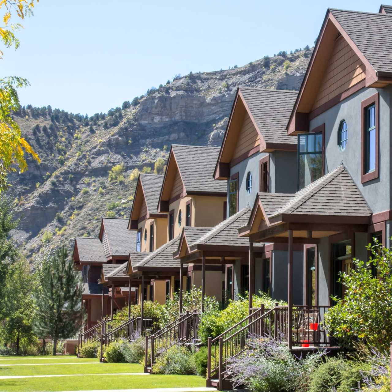 A row of houses with balconies nestled against a steep hillside