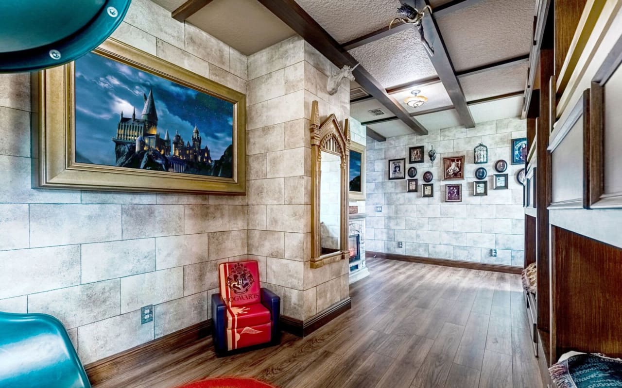 A bedroom with a painting of a castle on the wall.