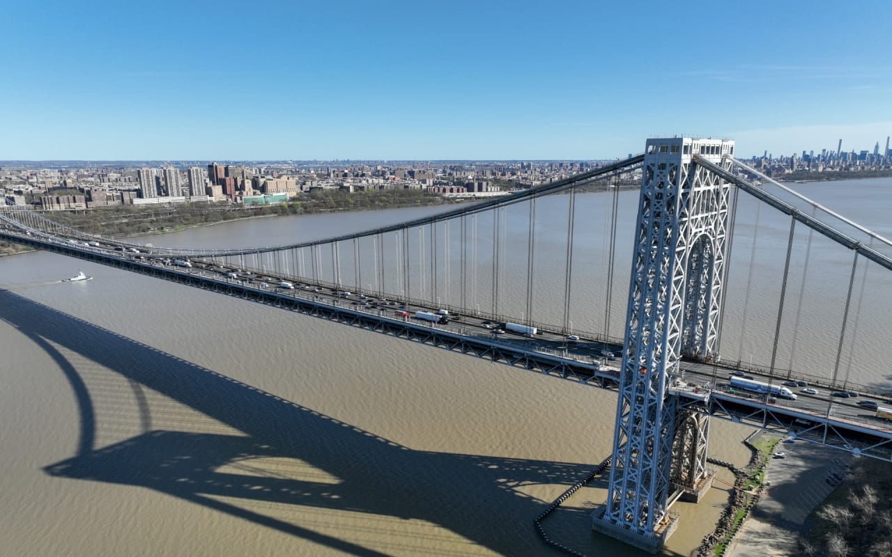 An aerial view of a suspension bridge with four lanes of traffic.