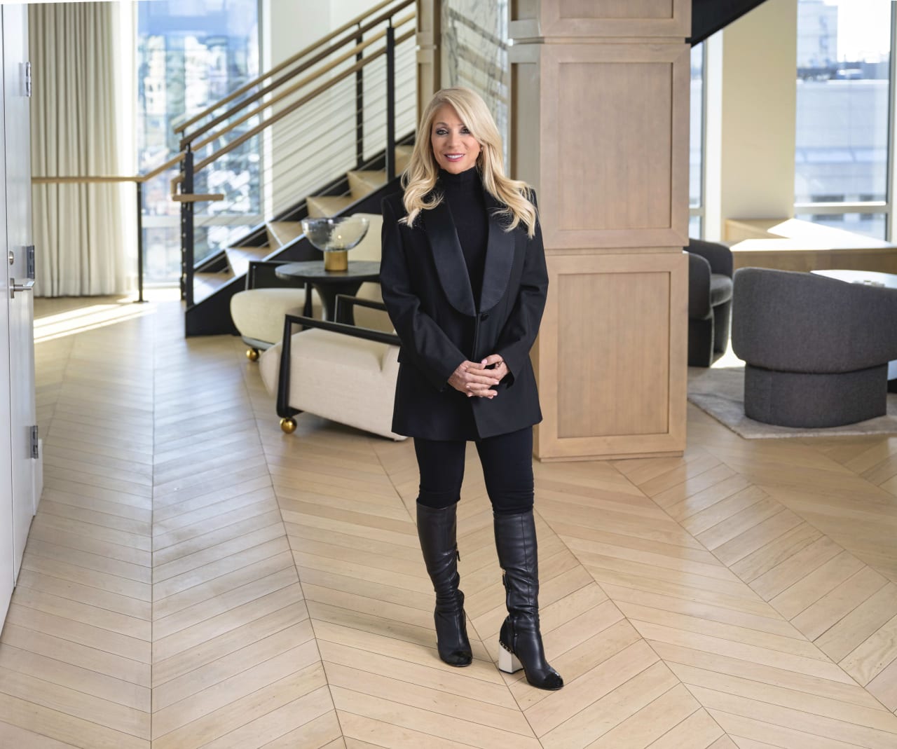 Louise Touchette, in an all-black outfit, stands confidently and wears a warm smile as she poses for a photograph