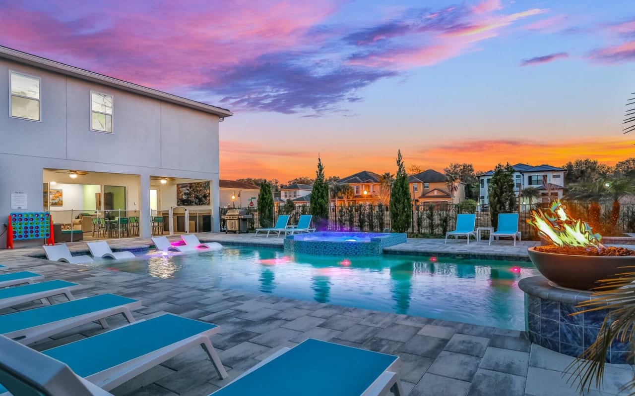 A large swimming pool with a blue liner in a twilight outdoor space.