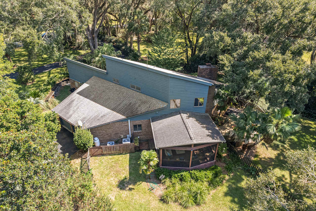 Aerial view of a secluded home nestled among lush green trees in a tranquil forest setting.