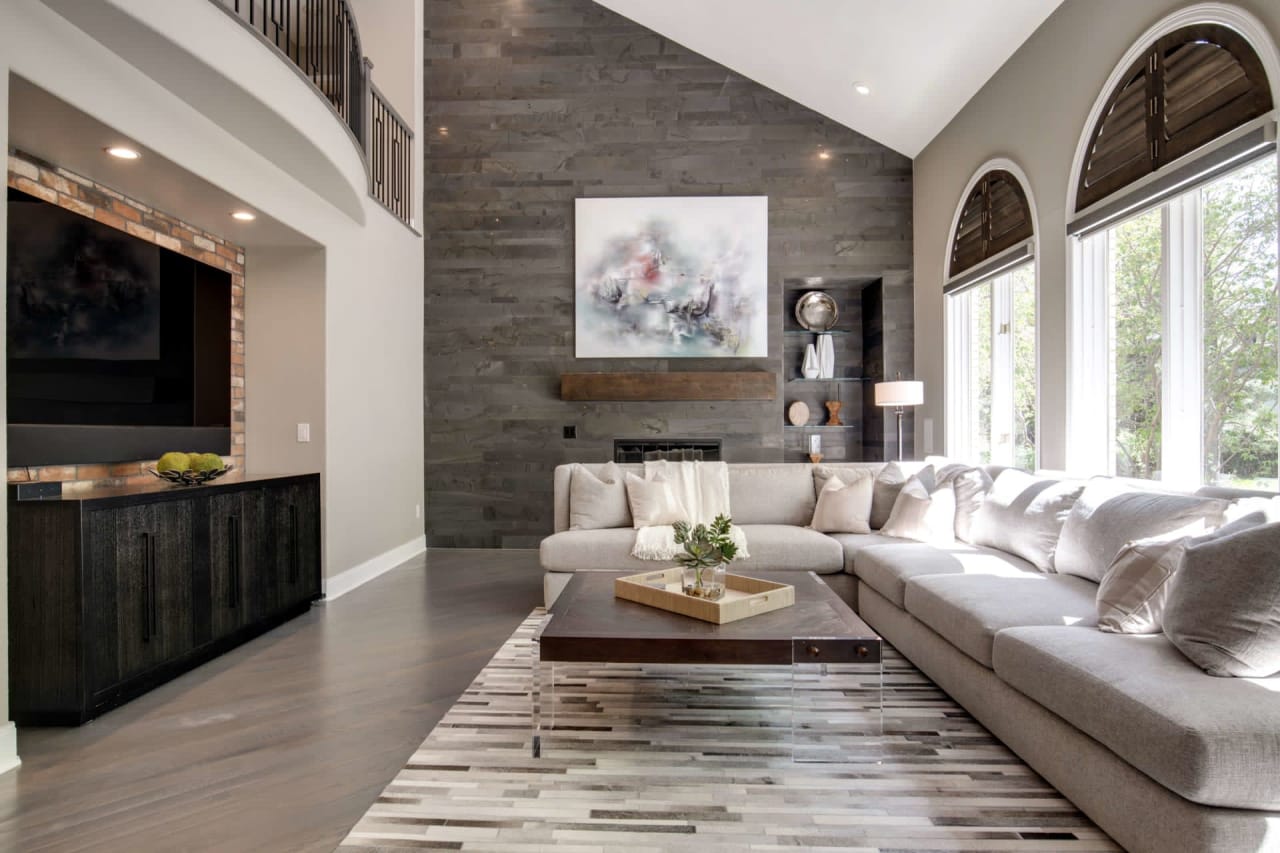 A living room with a couch, coffee table, fireplace, and TV