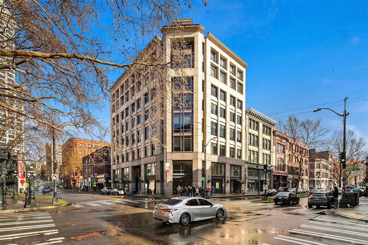 Corner view of a classic, elegant condo building at a bustling city intersection, embodying downtown luxury.