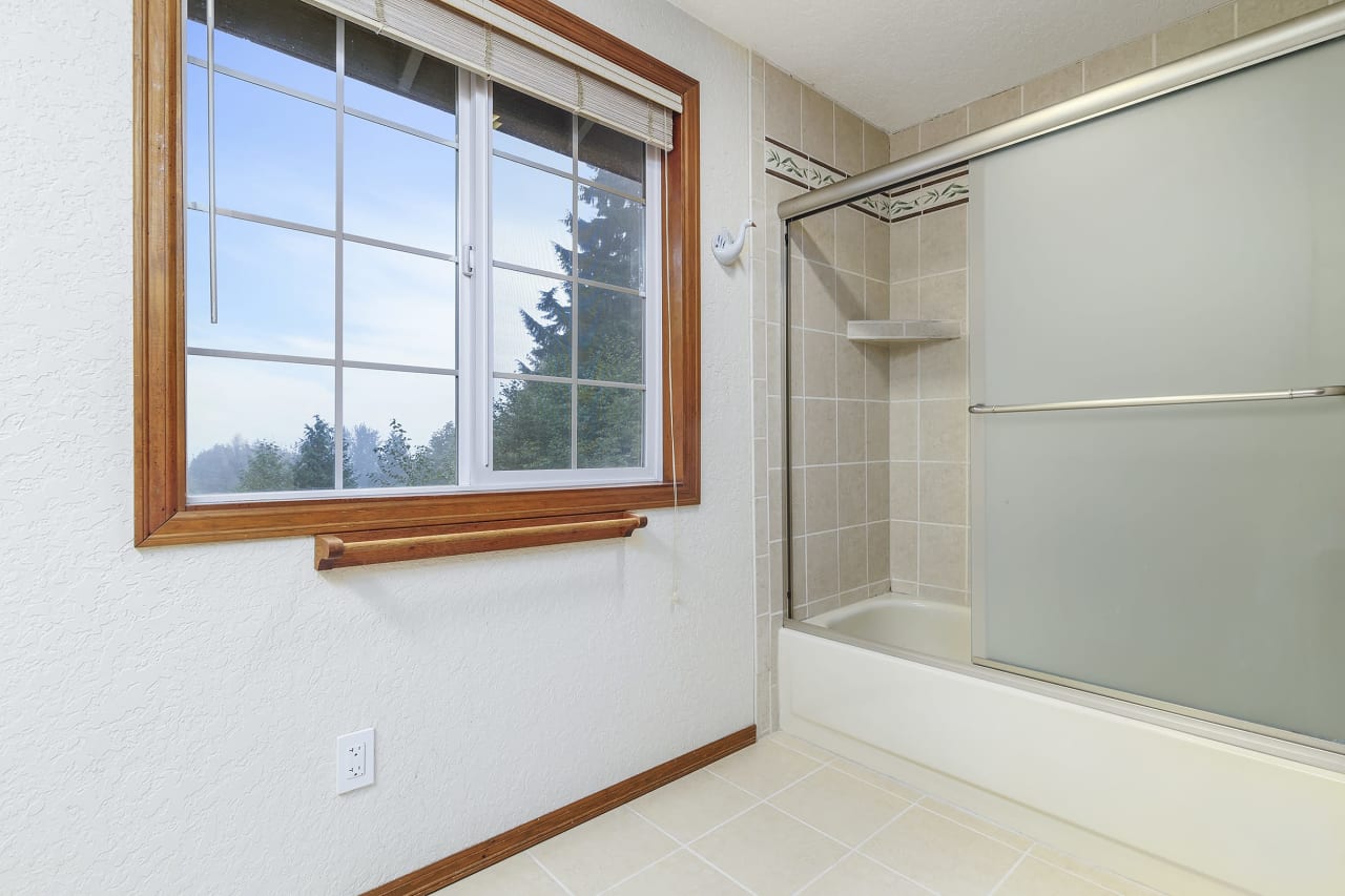 Within the primary bedroom's dual bathrooms, you'll find a lovely tiled tubs, and windows that offers picturesque views of the mountains, providing a serene and relaxing bathing experience.