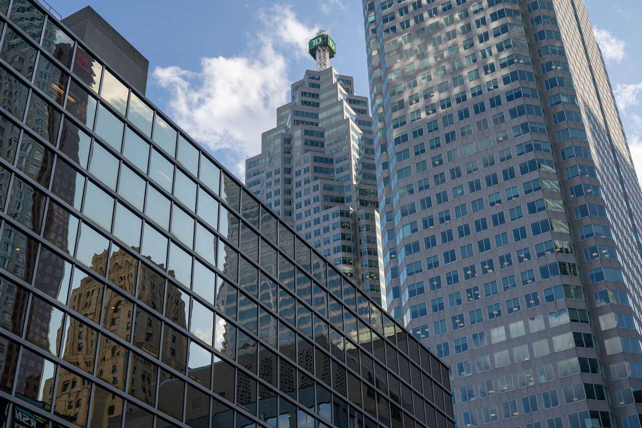 A modern skyscraper reflecting the city skyline and clouds above