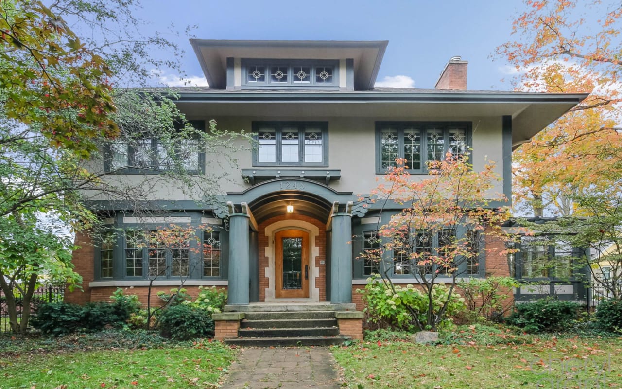 A single family house with a lot of windows and surrounded by trees