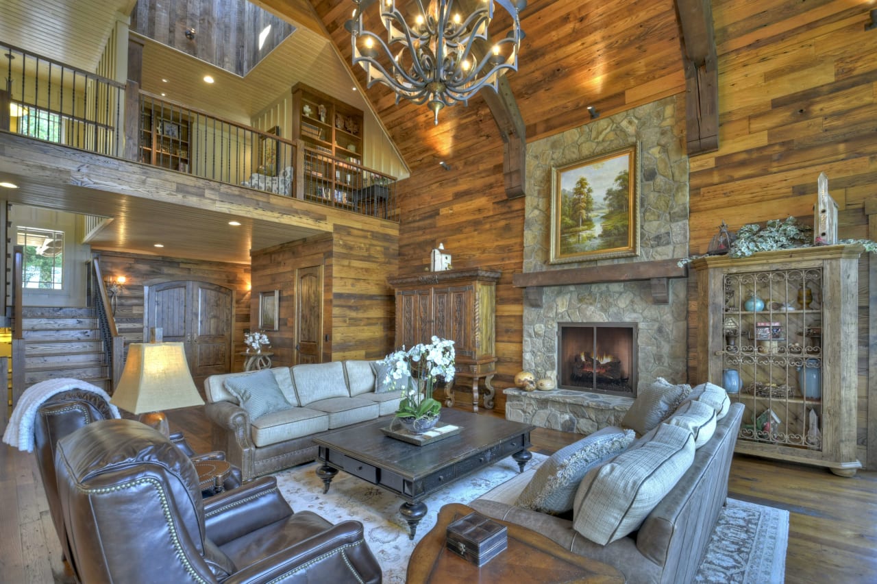 A cozy living room with a fireplace and a chandelier hanging from the ceiling.