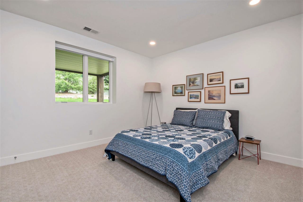 simple bedroom with blue bed sheets and picture frames in the wall