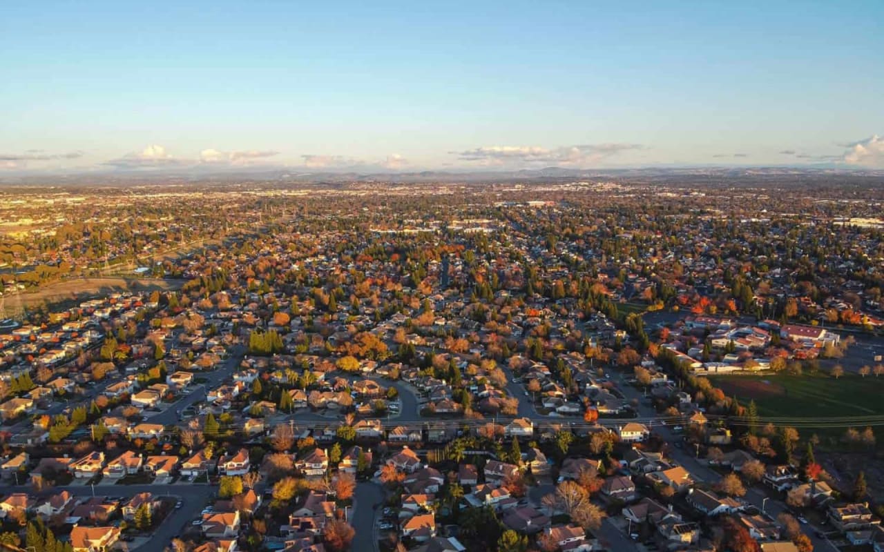 An aerial view of a suburban neighborhood in the fall. 