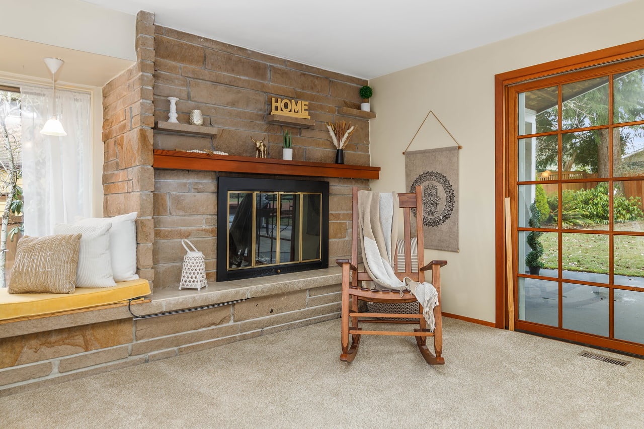 The rock fireplace adds a cozy touch to the living room, creating a warm and inviting atmosphere perfect for relaxation and gatherings.