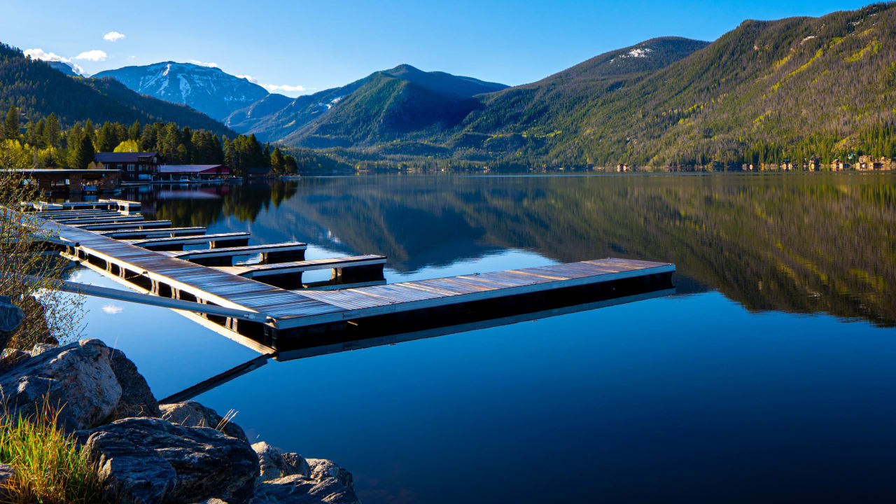 A dock on a lake with mountains in the background