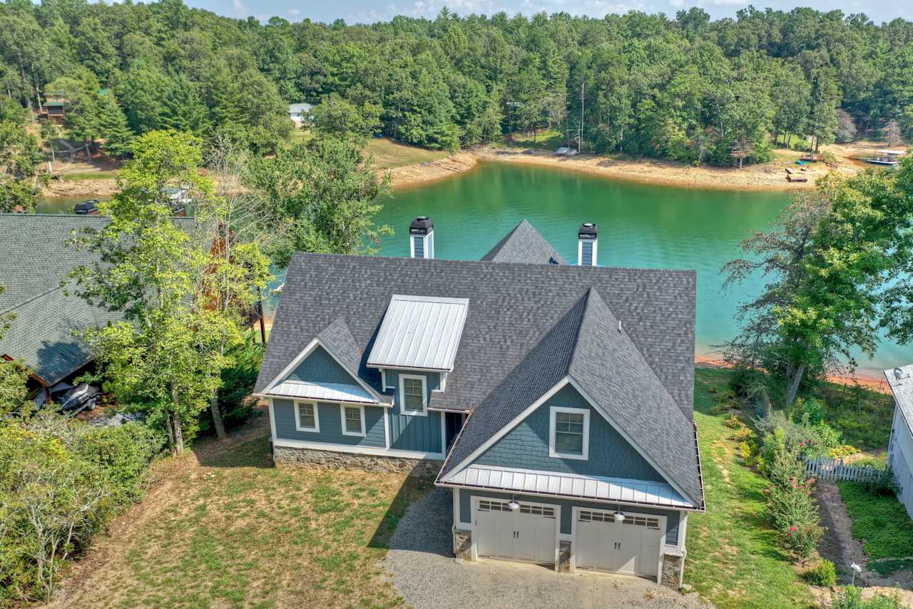 An aerial view of a house with a brown roof and a two-car garage.