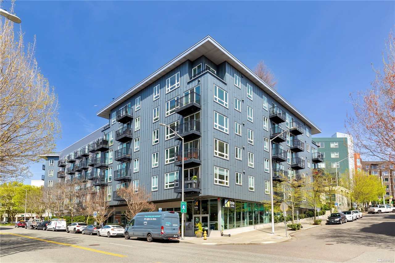 Modern condominium building on a sunny day, offering urban living with convenient access to city amenities.