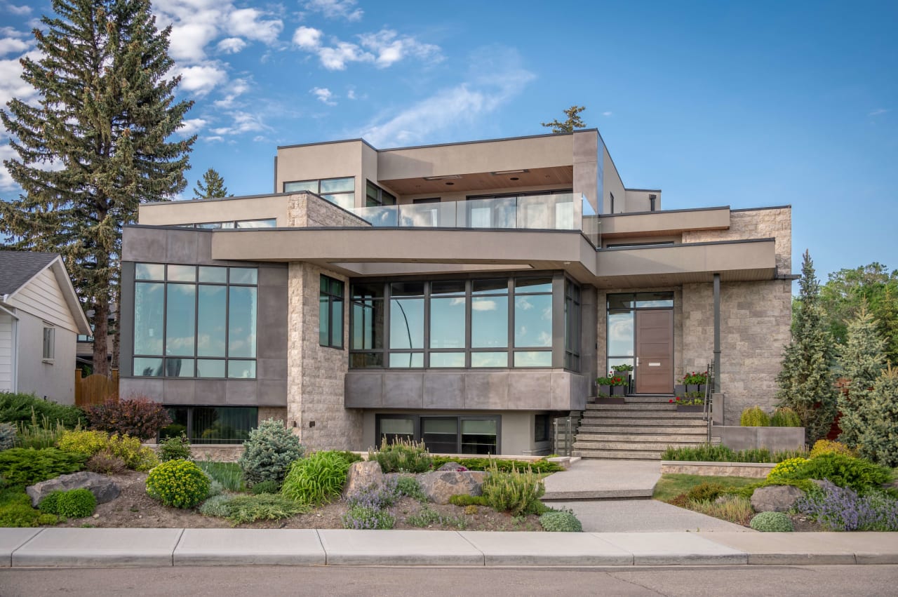 A large, modern house with floor-to-ceiling windows and a balcony.