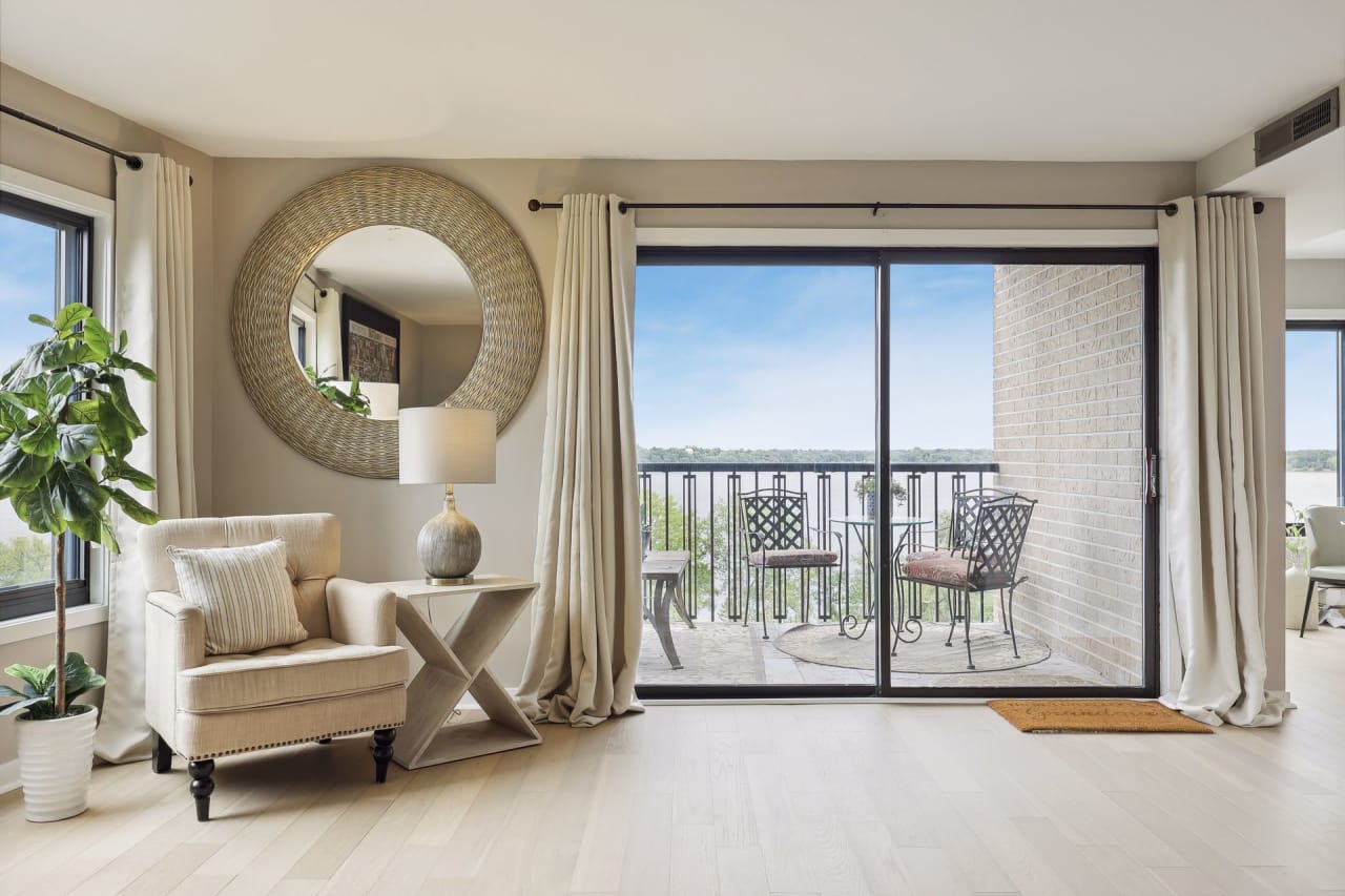 A spacious living room with a sliding glass door leading out to a balcony.