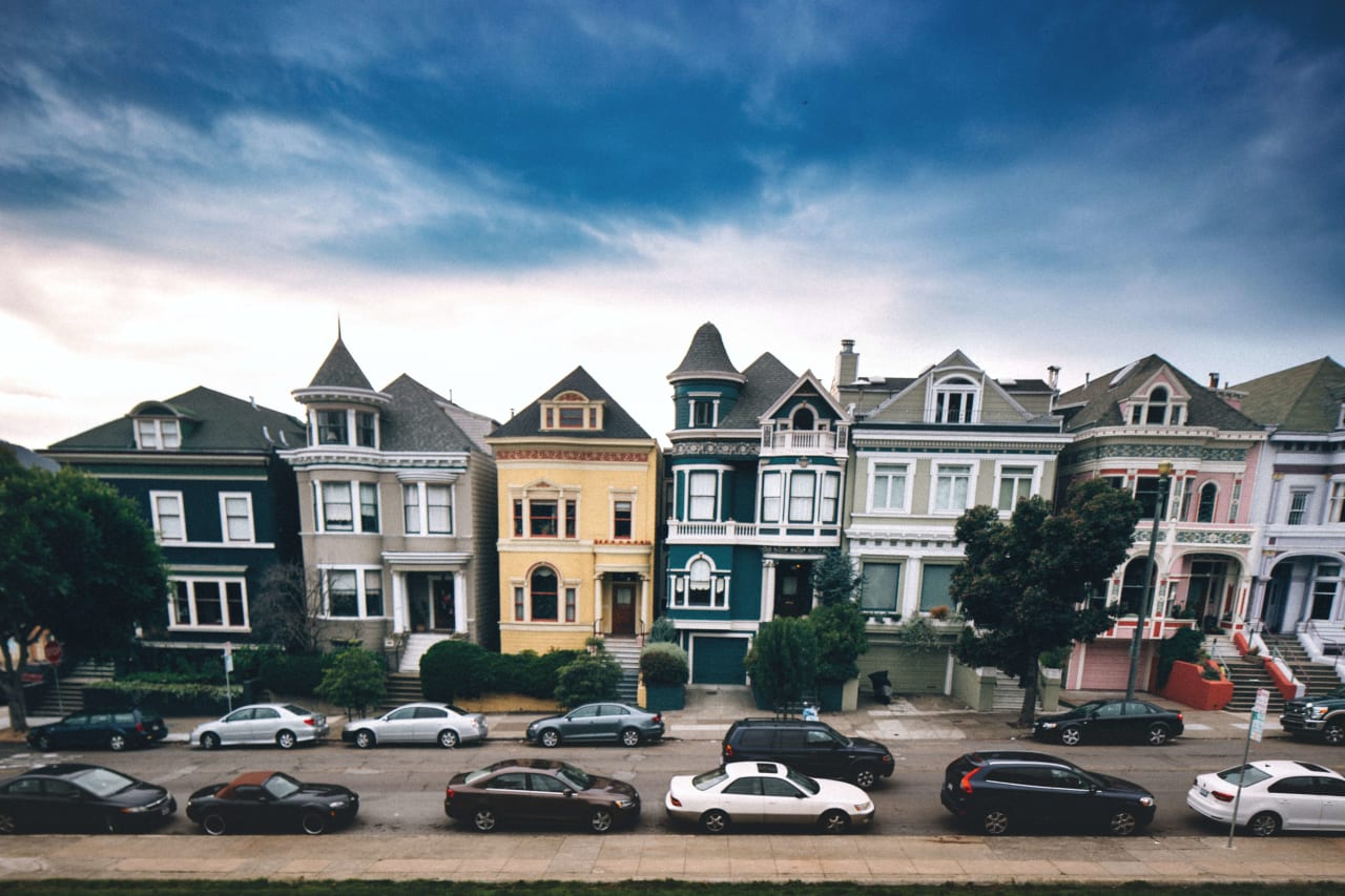 Victorian homes with blue skyline and cars parked in front | Legacy Real Estate