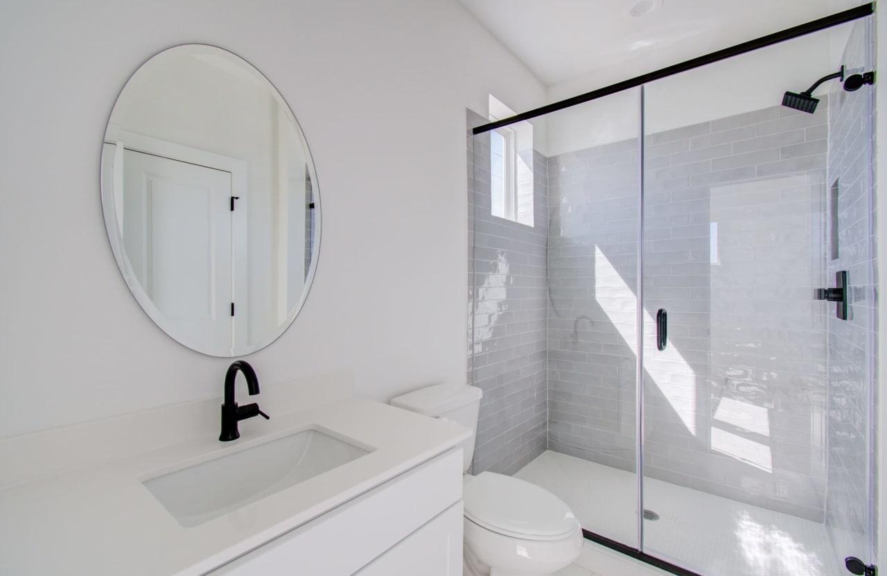 secondary bathroom with a round mirror 