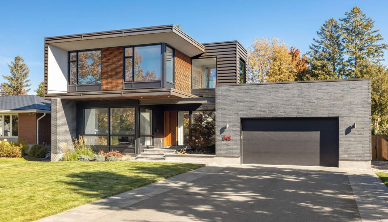 A charming minimalist 2-story house with a covered porch and a garage.