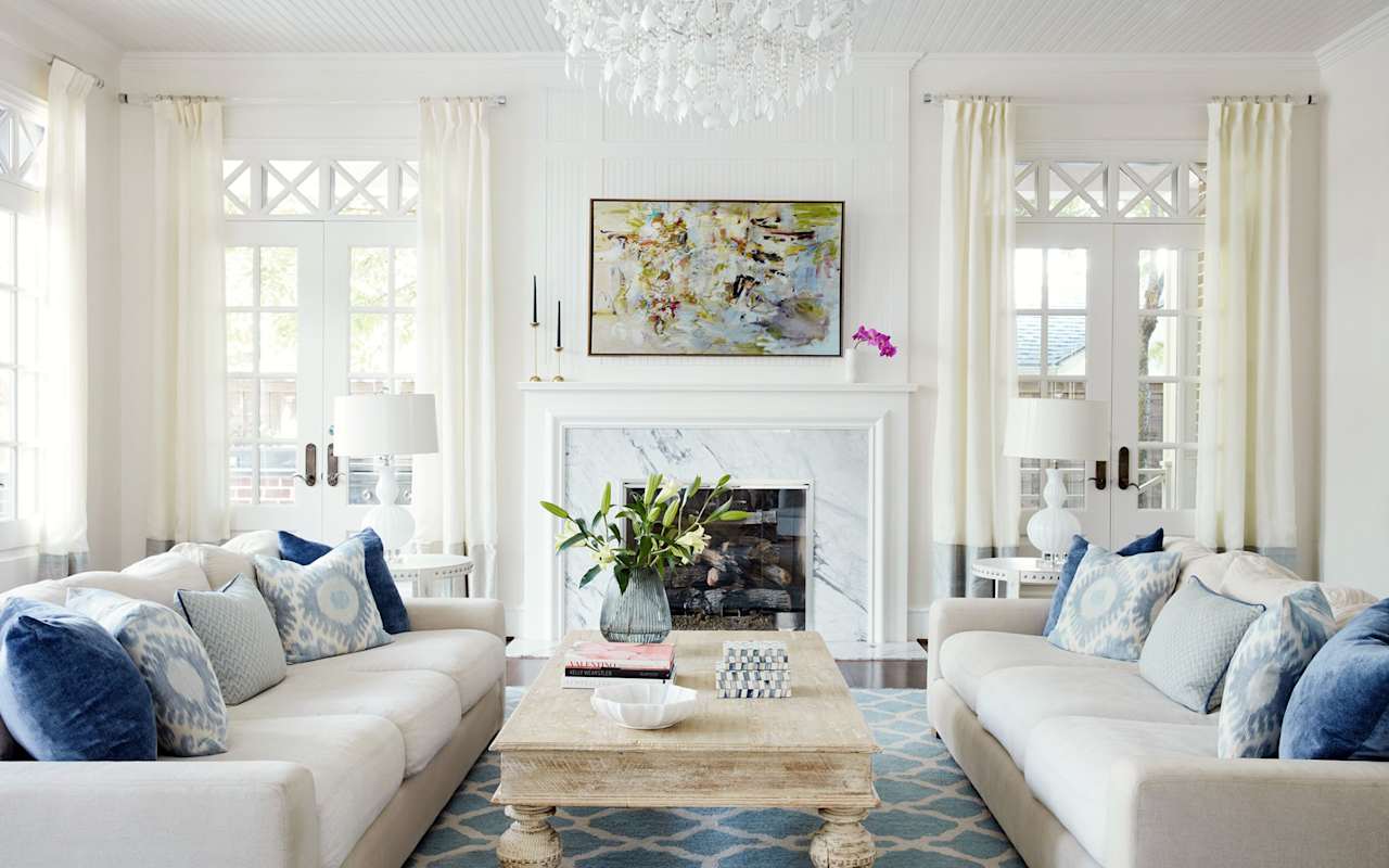 A living room with two couches, a coffee table, a fireplace, and a painting on the wall.