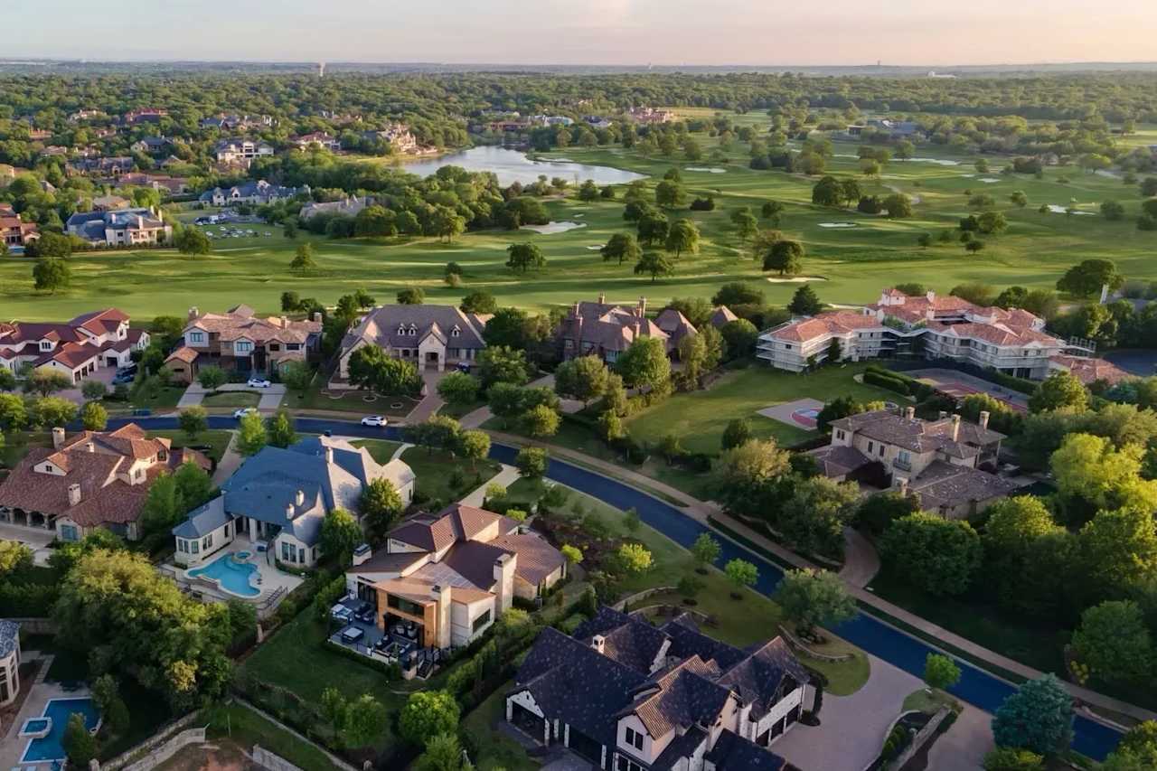 An aerial view of a residential neighborhood with houses, trees, and a golf course