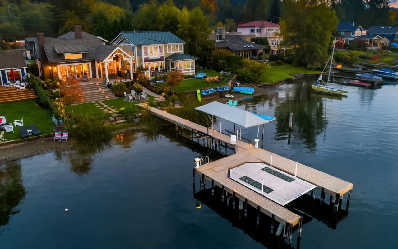 Large house with two-story garage and dock on a lake