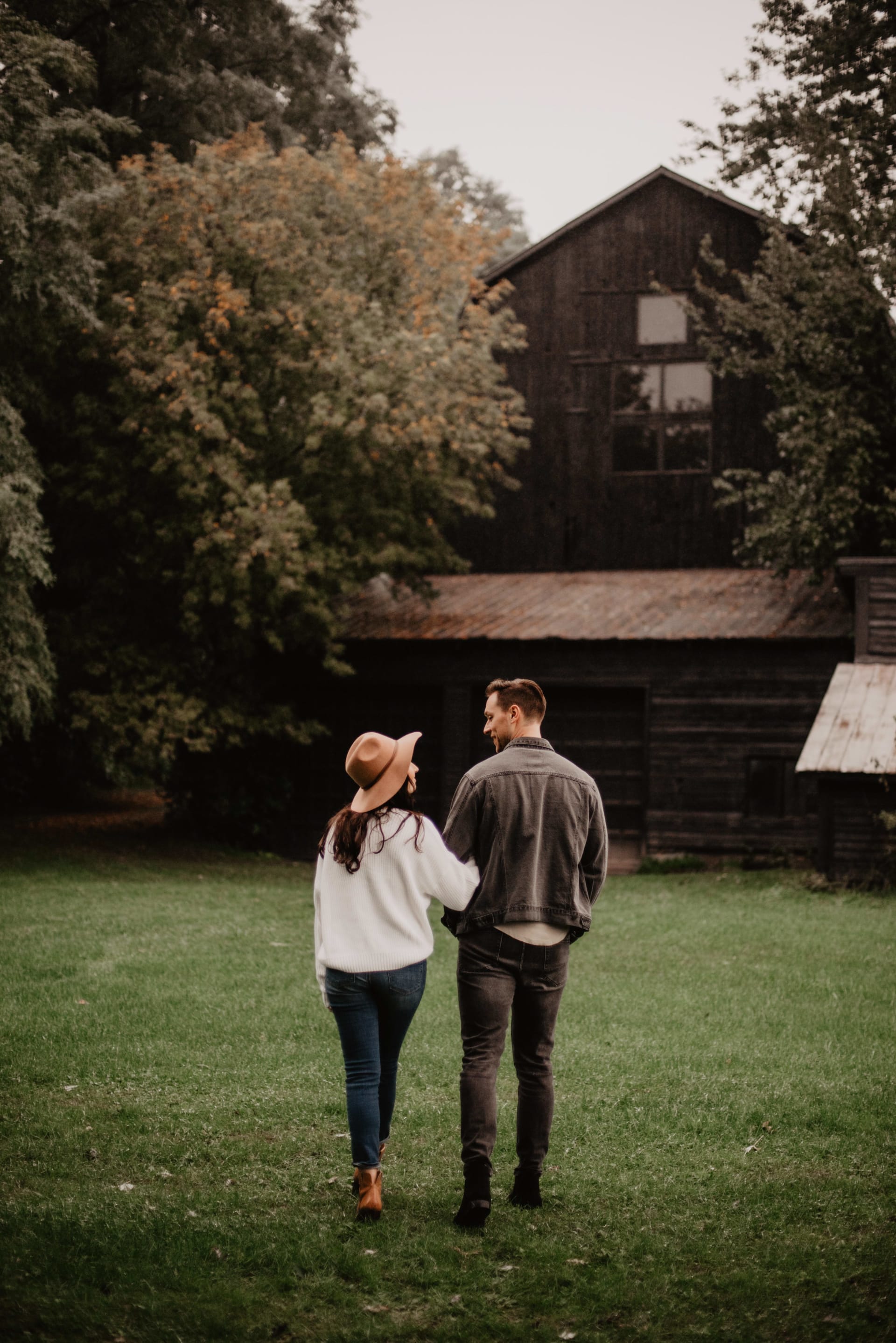 A man and a woman making eye contact as they walk towards a residential house