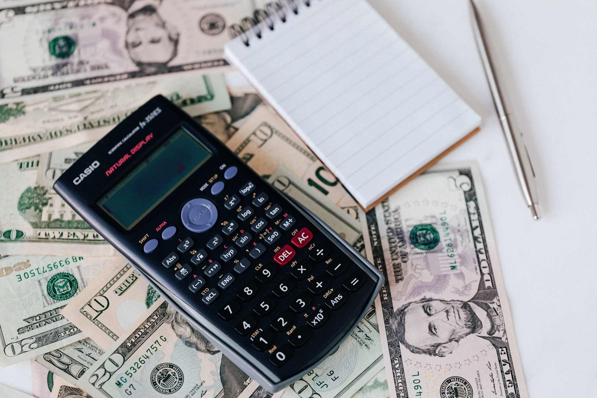 A calculator, a notepad, and money used to create a budget for your home purchase.