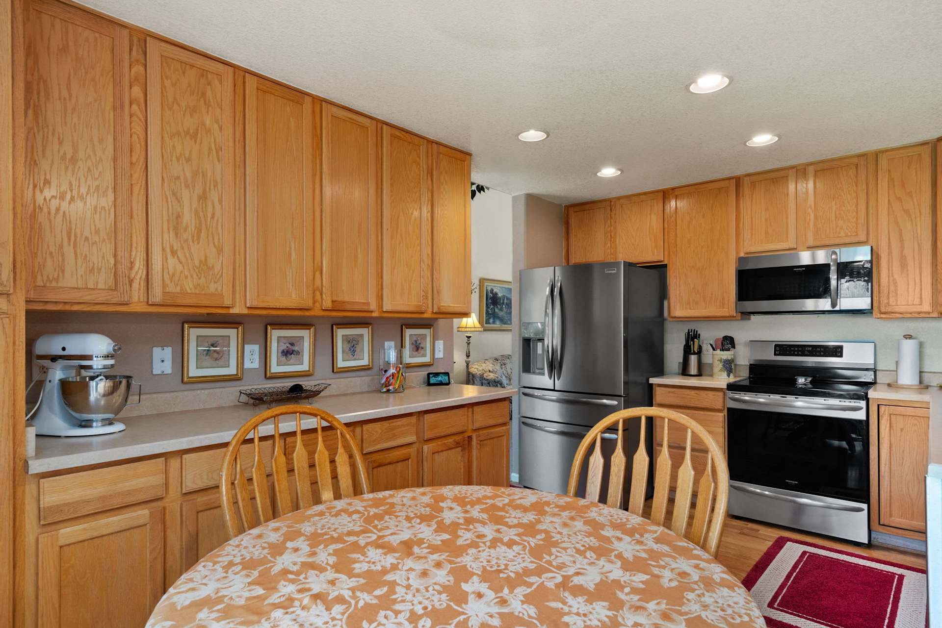 Kitchen with extensive honey-colored wood cabinets and a round dining table in the foreground.
