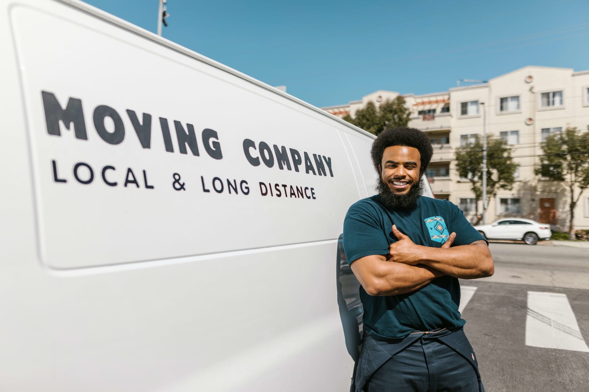 A man smiling next to a moving van