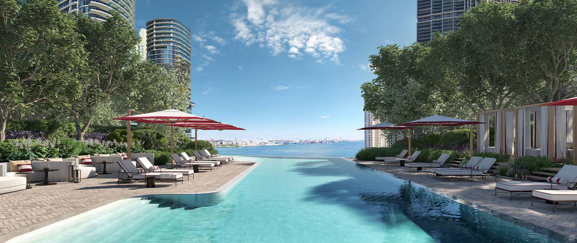 Pool deck with lounge chairs and umbrellas overlooking the waterfront and city skyline.