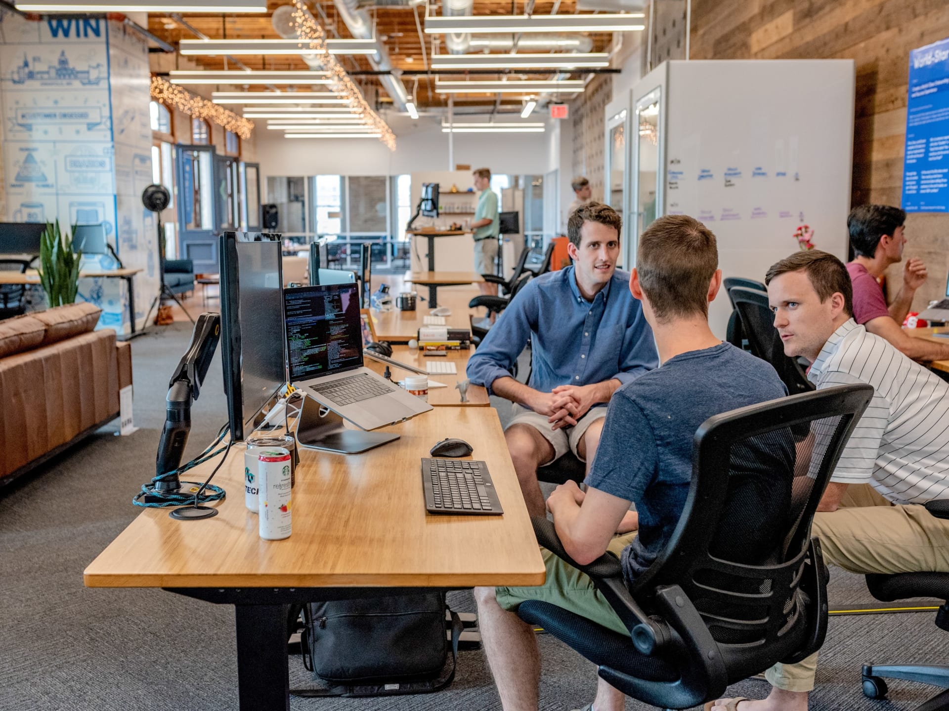 Three men engaged in a discussion in an office setting