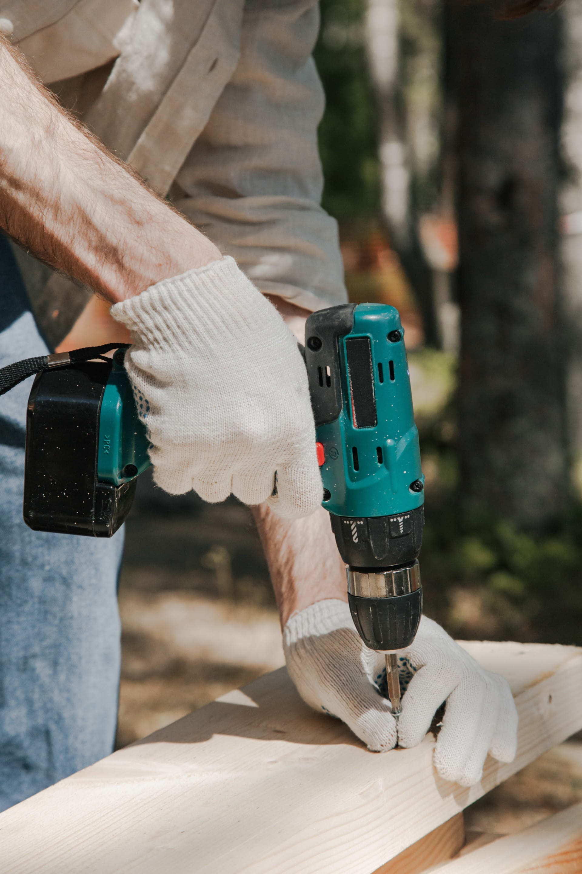 A visual representation of the house renovation concept, featuring a man using an electric screwdriver on a piece of wood.