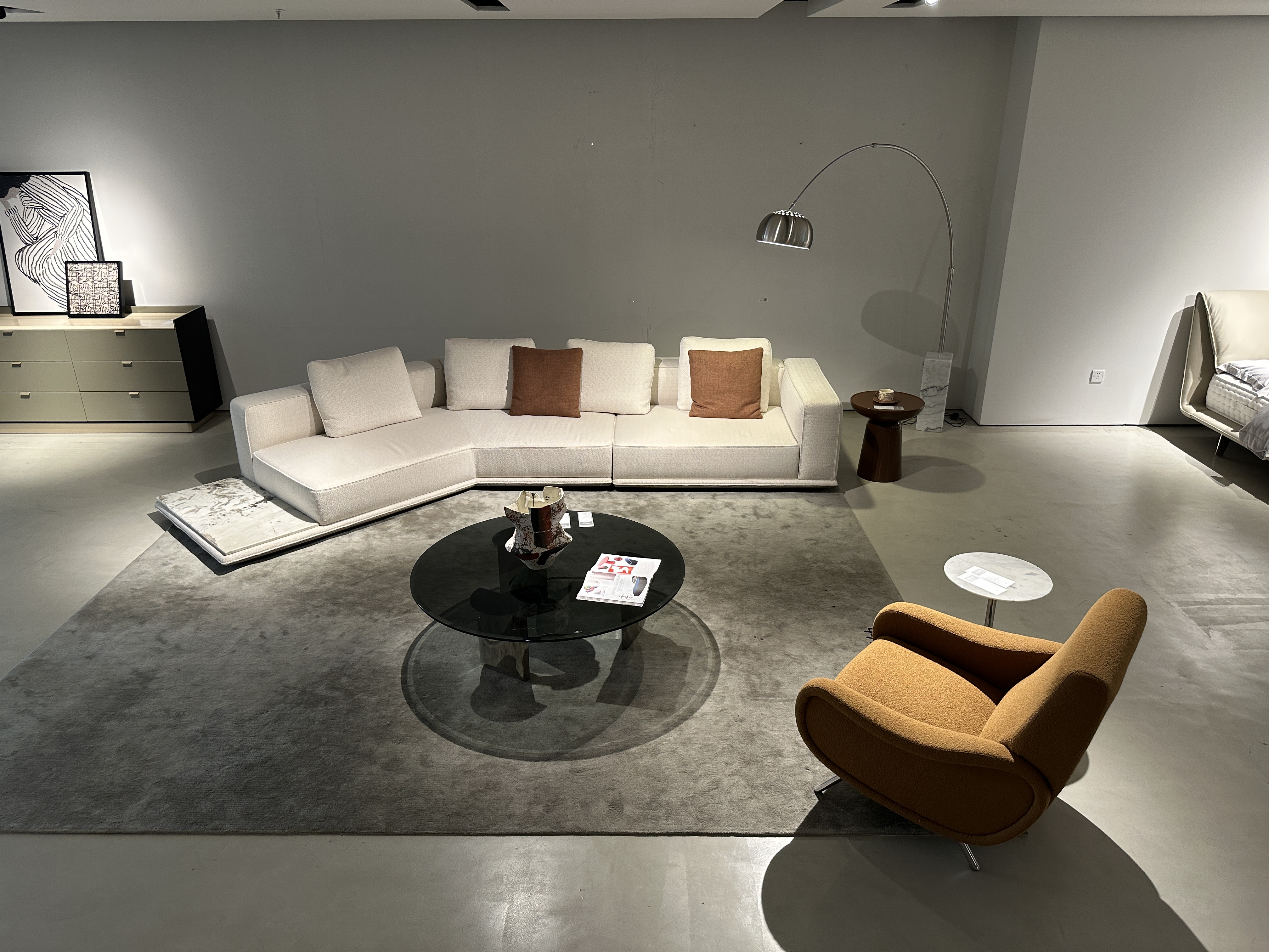 Low-profile modular sofa with terracotta pillows beside a mustard lounge chair