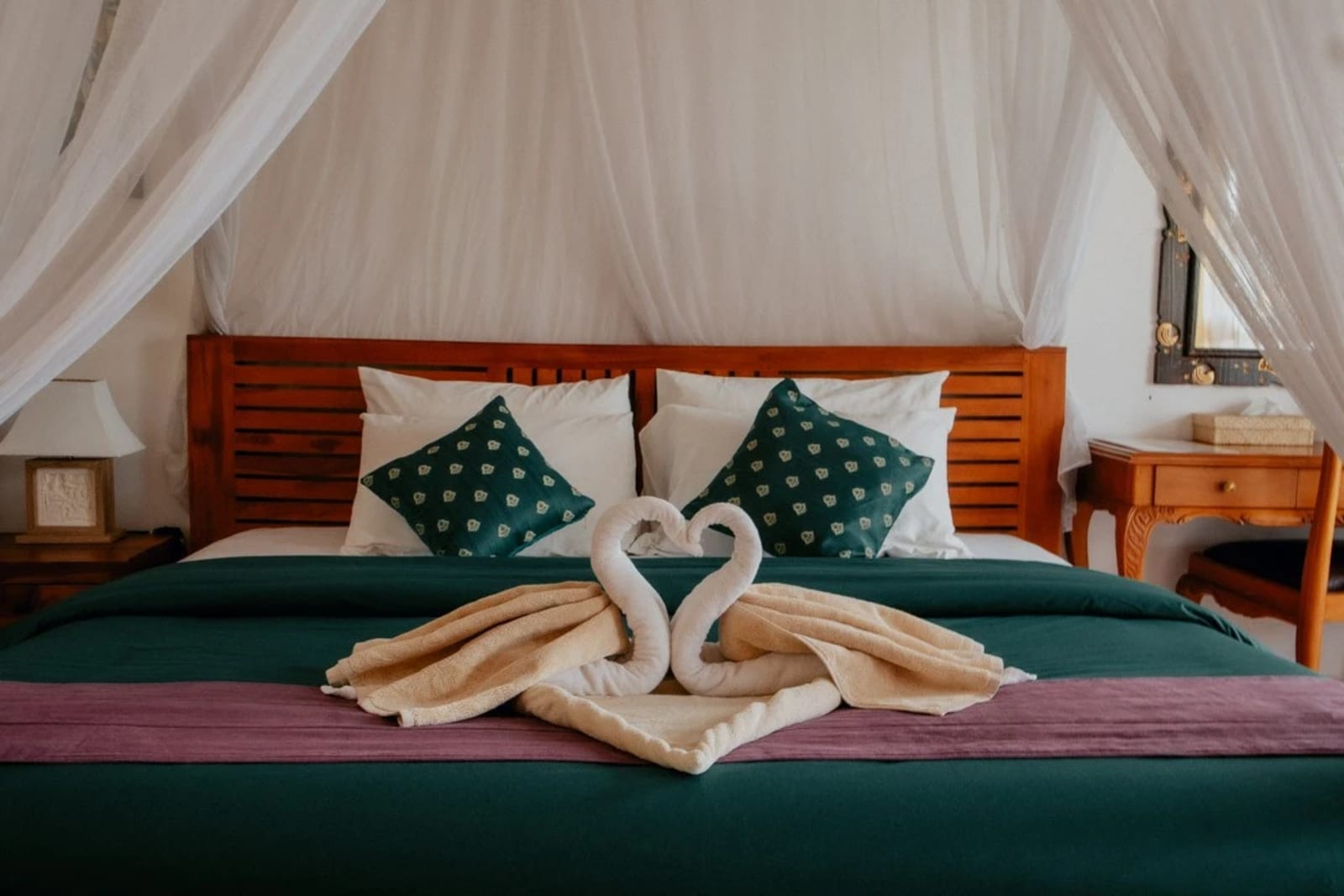 Puri Sunny Deluxe Room with teak canopy bed and balcony