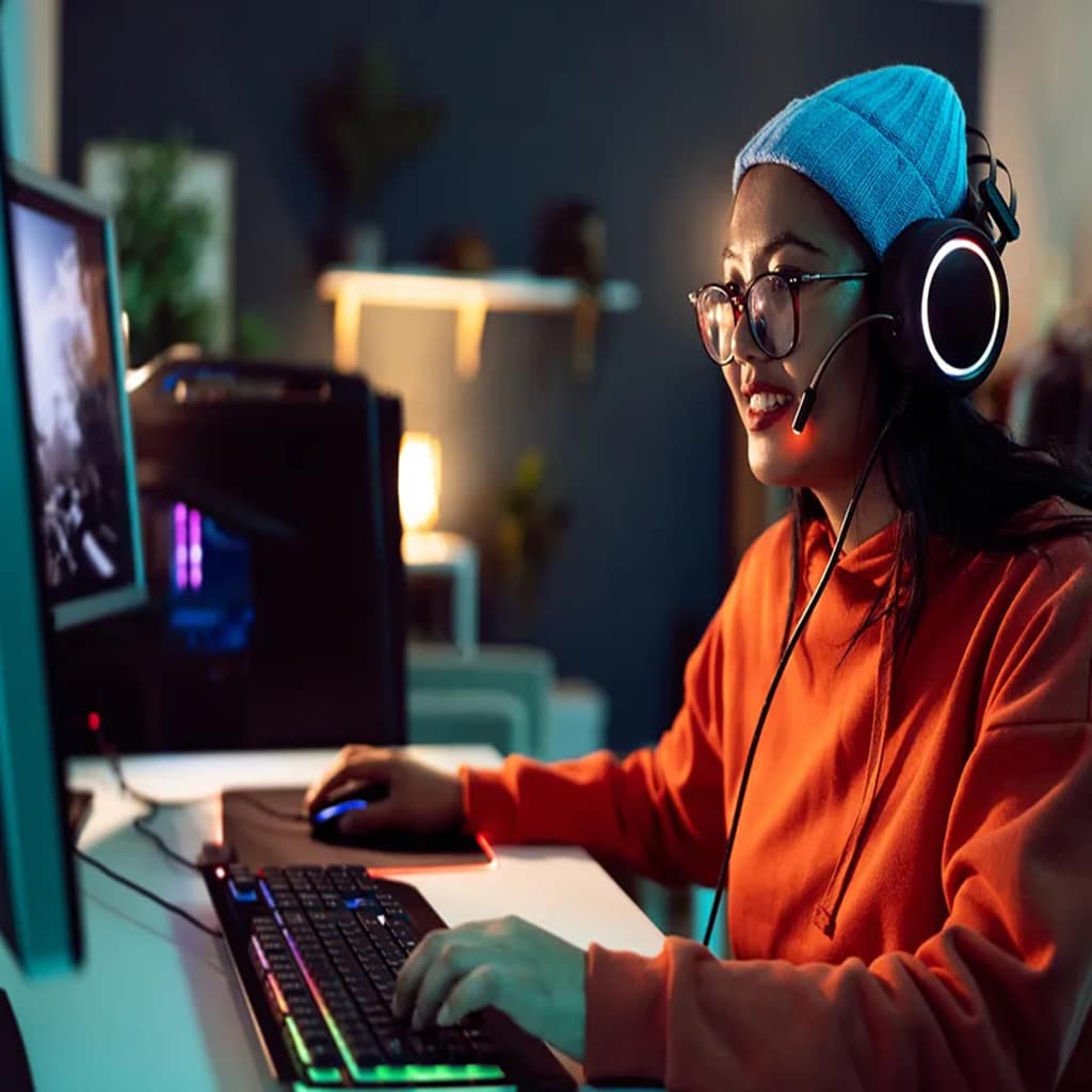 A gamer smiles as she navigates her VPS on a computer monitor.