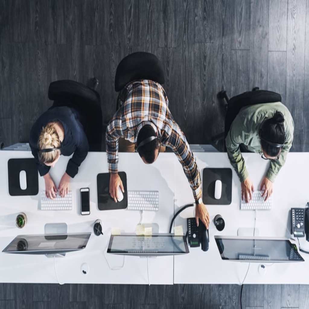 An overhead view of people on a computer.
