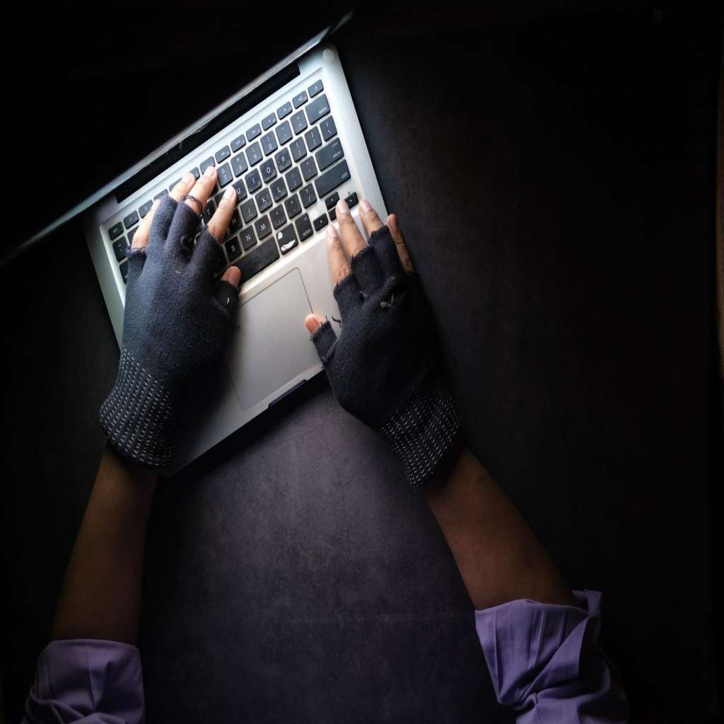 Hacker typing on a laptop.