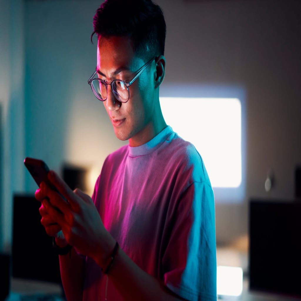 Guy looking at his phone in the dark